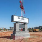 A crane installing a large commercial monument sign at a new development in Columbus Ohio